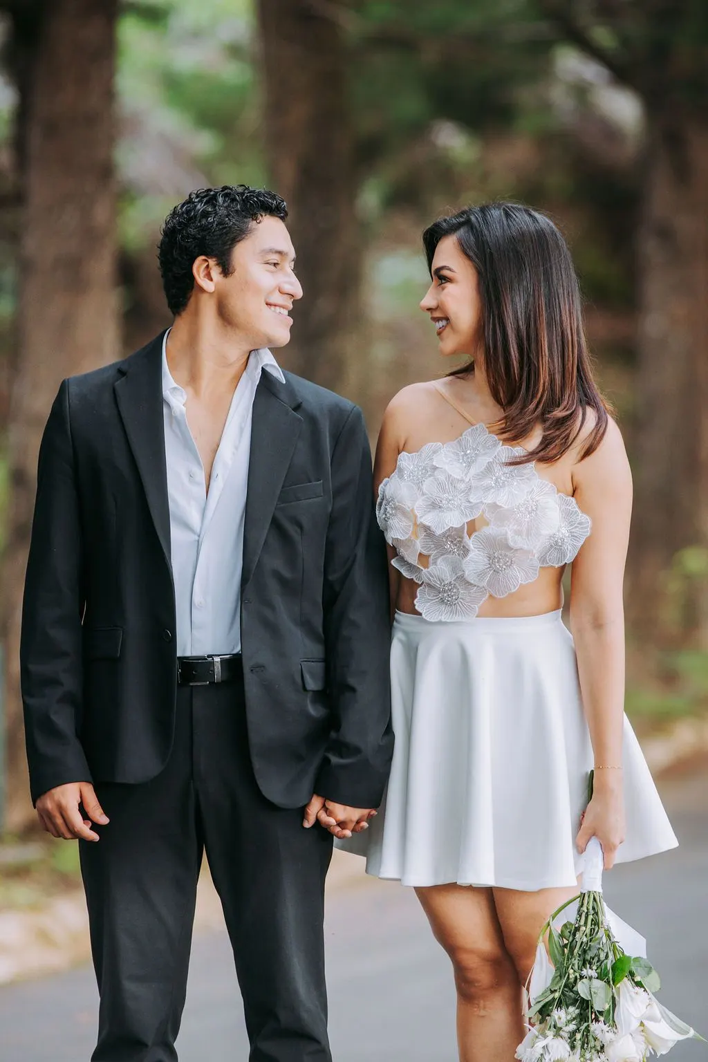 La pareja se mira sonriendo, tomada de la mano